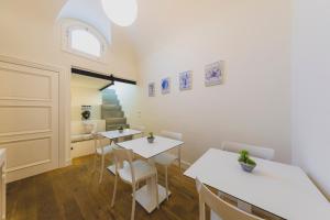 Pokój z dwoma stołami i krzesłami oraz schodami w obiekcie Cefalù Design Suites w Cefalù