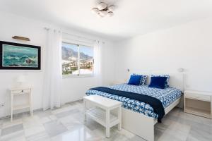 a white bedroom with a bed and a window at Home2Book Stunning Sea Views Adeje, Wifi & Pool in Playa Fañabe