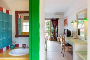 baño con bañera y cocina con mesa. en Casa Brazil Homestay en Karon