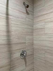 a shower with a shower head in a bathroom at Pacific Inn Anaheim in Anaheim