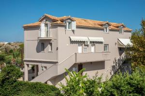 ヴァシリコスにあるAvesta Apartments - 200m from the beachの白い大きな瓦屋根の建物