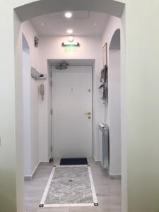 um corredor com uma porta branca e piso em azulejo em Victoria Luxury Apartment 11 em Bucareste