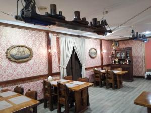 un restaurante con mesas de madera y sillas en una habitación en Uspenskaya Hotel, en Uglich