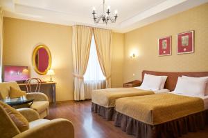 a hotel room with two beds and a chandelier at Admiralteyskaya Hotel in Saint Petersburg