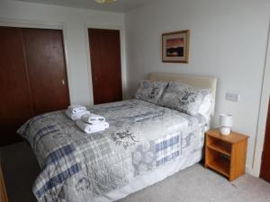 a bedroom with a bed with two towels on it at Smithy Cottage in Blairgowrie