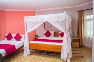 - une chambre avec deux lits et un lit à baldaquin dans l'établissement Burch's Resort Naivasha, à Naivasha