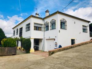 Un gran edificio blanco con ventanas. en Casa Cantarrana, en Arriate