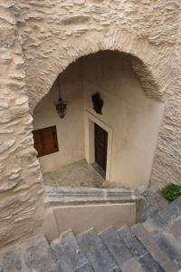 un edificio de piedra con puerta y ventana en Hotel Palazzo Bruni en Maierà