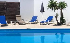 a group of blue chairs and a swimming pool at Silver Seahorse Garden Retreat in Peniche