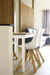 una mesa y 2 sillas blancas en una habitación en Quinta do Mocho Turismo Rural, en Estói