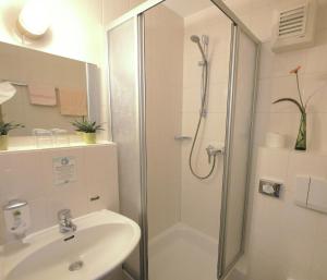 y baño con ducha y lavamanos. en Hotel Landgasthof Blume en Lichtenau