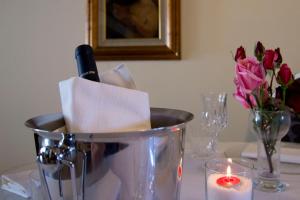 - un seau avec une bouteille de vin et des fleurs sur une table dans l'établissement Affittacamere Villa Serafini, à Remanzacco