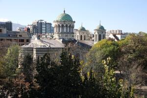 a group of buildings with green domes in a city at COLORED HOUSE Apartments in Sofia