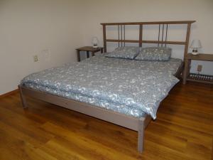 a bed in a bedroom with a wooden floor at Villa La Vita in Hévíz