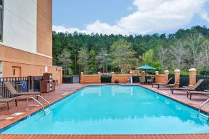 a swimming pool at a hotel with chairs and a building at Hyatt Place Birmingham/Hoover in Hoover