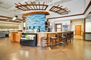 a restaurant with a bar with stools in a room at Hyatt Place Albuquerque Uptown in Albuquerque