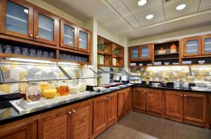 a large kitchen with wooden cabinets and drinks on display at Hyatt Place Minneapolis Airport South in Bloomington