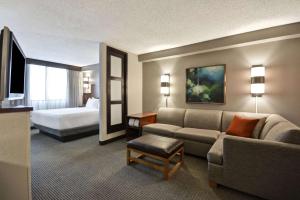 a hotel room with a couch and a bed at Hyatt Place Miami Airport-West/Doral in Miami