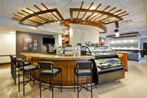 a restaurant with a bar with chairs around it at Hyatt Place Kansas City/Overland Park/Metcalf in Overland Park