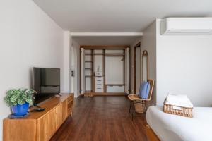 a bedroom with a bed and a television on a dresser at The Earth Hotel in Chiang Mai