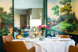 馬孔的住宿－Hôtel Restaurant Gastronomique La Huchette，一张桌子上放着白色桌布和鲜花