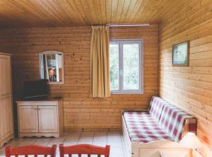 a living room with a couch and a window at Terres de France - Natura Resort Pescalis in Moncoutant