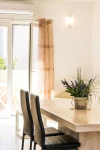 a dining room table and chairs with a potted plant on it at Apartments Pineta in Cunski