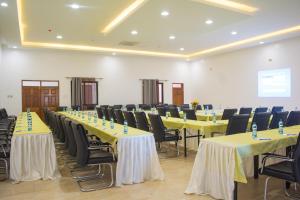 Burch's Resort Naivasha في نيفاشا: صف من الطاولات والكراسي في الغرفة