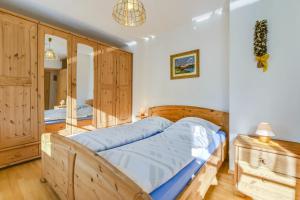 Un dormitorio con una cama de madera y un espejo. en Katharinenhof Ferienwohnung Alpspitz (4), en Garmisch-Partenkirchen