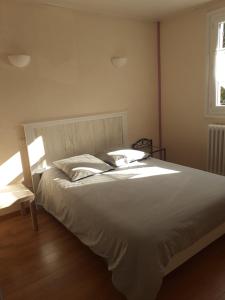 Isle-et-Bardaisにあるle rond gardienのベッドルーム(大きな白いベッド1台、窓付)