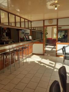 a restaurant with a bar and chairs in a room at le rond gardien in Isle-et-Bardais