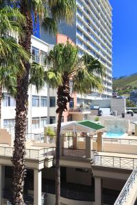 two palm trees in front of a large building at Urban Oasis at The Square in Cape Town