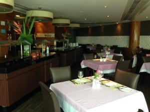 uma sala de jantar com uma mesa branca e um bar em Flat Beira Mar em Recife no Recife