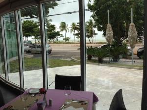 uma mesa com uma toalha de mesa roxa e óculos em Flat Beira Mar em Recife no Recife