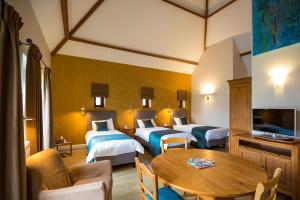 une chambre d'hôtel avec deux lits et une table dans l'établissement B&B Ferme Château de Laneffe, à Laneffe