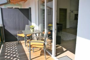 a balcony with a table and chairs on a patio at Ferienwohnungen Rosenhof in Tegernsee