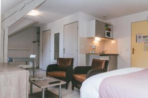 阿勒瓦的住宿－法國之地- 錦繡公寓式酒店，酒店客房配有一张床、两把椅子和一张桌子