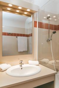 a bathroom with a sink and a shower at Terres de France - Appart'Hotel le Splendid in Allevard