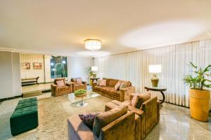 a living room filled with furniture and a large window at Plaza Inn Executive in Goiânia