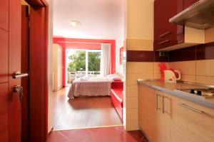 a kitchen with a room with a bed and a window at Resort Trcol in Novalja