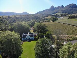 une vue aérienne d'une maison dans un champ avec des montagnes dans l'établissement Navarre Farm Cottages, à Stellenbosch