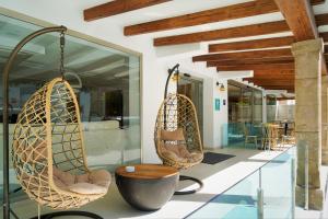 a lobby with two hanging chairs and a table at Hotel Seasun Aniram in Playa de Palma