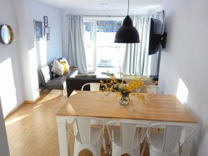 Ushuaia Homes Martial Apartments في أوشوايا: غرفة معيشة مع طاولة طعام مع كراسي