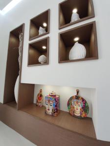 a shelf with plates and vases on it at Sea Elegance in Oliveri