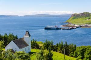 a cruise ship in a large body of water with a church at Stones Luxury B&B with hot tub and self-contained rooms in Uig