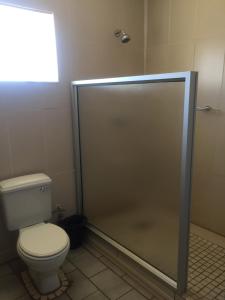 a bathroom with a toilet and a shower stall at Hae Bed and Breakfast in Leribe