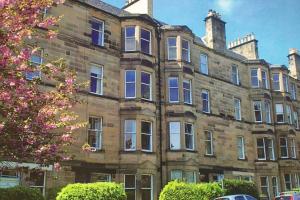 愛丁堡的住宿－Woodburn Terrace, Morningside, Edinburgh，一座带窗户和树的大型砖砌建筑