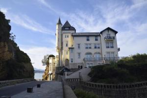 a large white building with a tower on a hill at au calme in Anglet