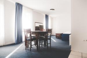 a room with a table and chairs and a bed at Terres de France - Appart'Hôtel La Roche-Posay in La Roche-Posay