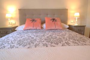 ein Schlafzimmer mit einem Bett mit zwei rosa Kissen in der Unterkunft Urcatusa Llevant - Apartamento 6 pax con piscina g27034 in Sant Feliu de Guixols